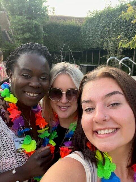 Three women in a garden, smiling at the camera